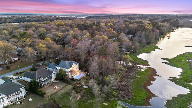 aerial view at dusk featuring a water view