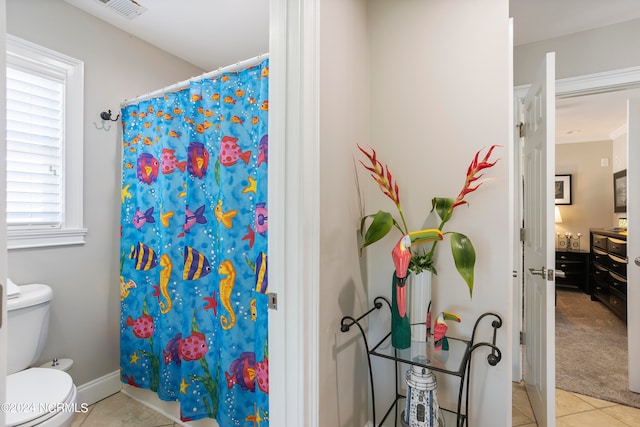 bathroom featuring toilet, tile flooring, and plenty of natural light