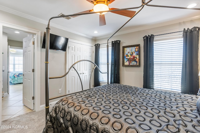 tiled bedroom with ceiling fan, a closet, multiple windows, and crown molding