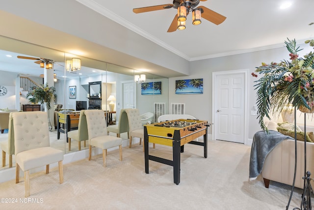 game room featuring ceiling fan with notable chandelier, ornamental molding, and light colored carpet