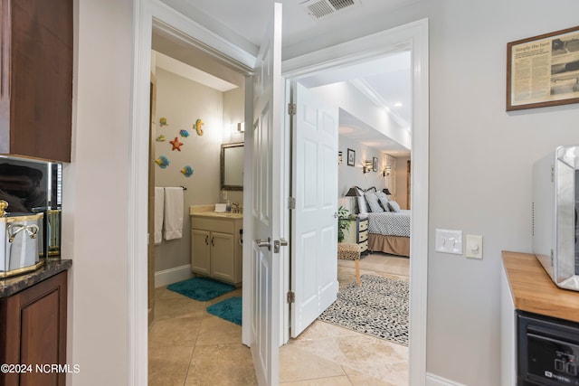 interior space featuring crown molding, tile floors, and vanity