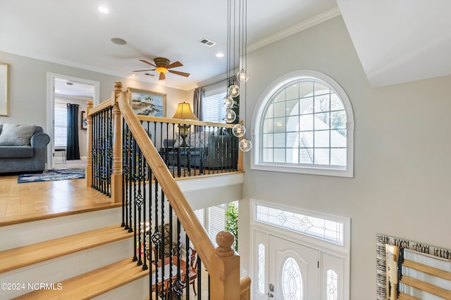 stairway featuring crown molding and ceiling fan