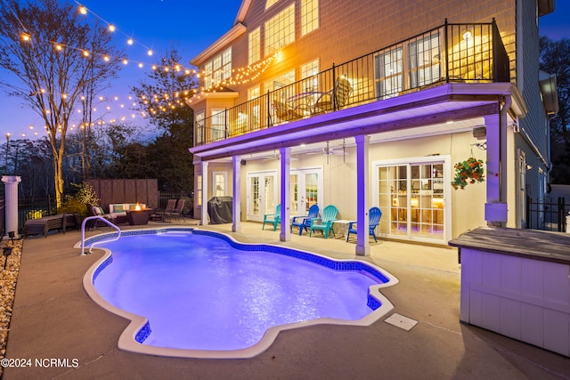 pool at dusk featuring grilling area, outdoor lounge area, french doors, and a patio