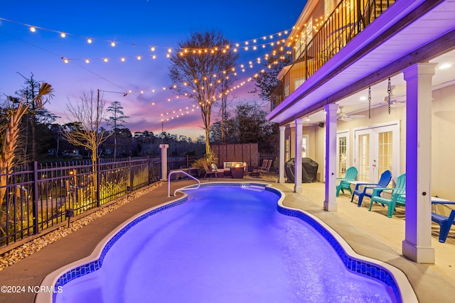 pool at dusk featuring a grill, ceiling fan, french doors, and a patio