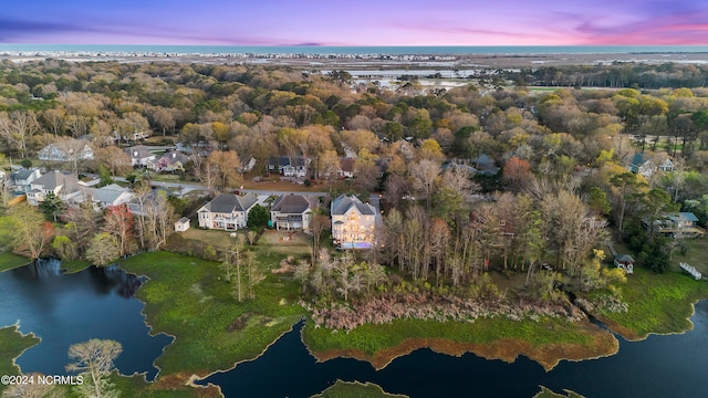 aerial view at dusk featuring a water view