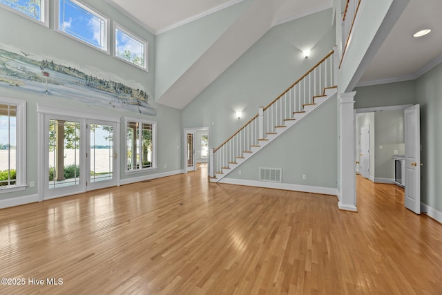 unfurnished living room featuring ornamental molding, light hardwood / wood-style flooring, and plenty of natural light