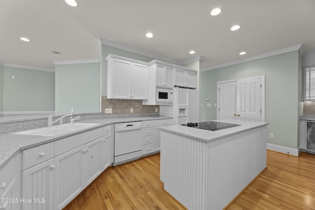 kitchen featuring white cabinetry, light hardwood / wood-style flooring, a kitchen island, sink, and white appliances