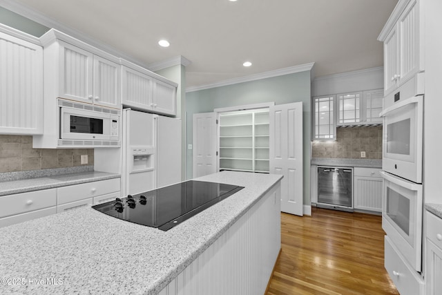 kitchen featuring wine cooler, light hardwood / wood-style floors, white appliances, tasteful backsplash, and white cabinets