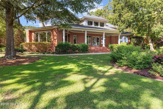 view of front of home with covered porch and a front lawn