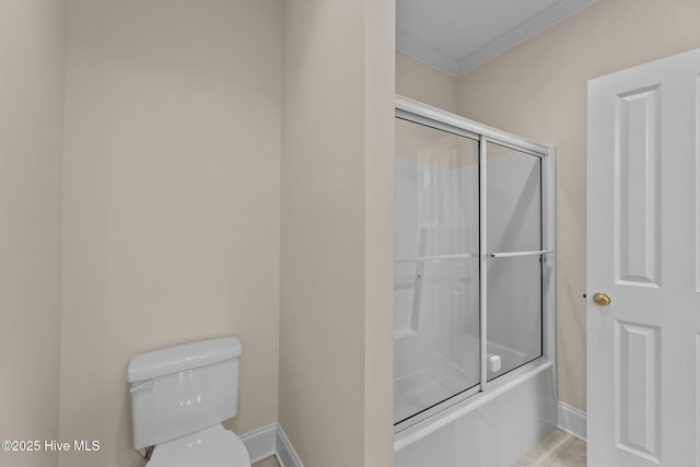 bathroom with shower / bath combination with glass door, crown molding, and toilet