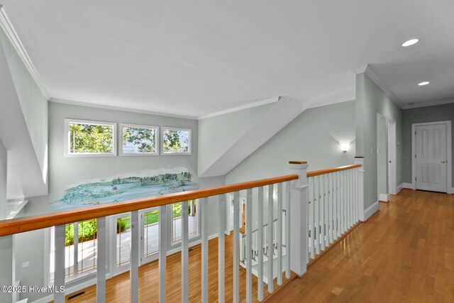 corridor with hardwood / wood-style floors and crown molding