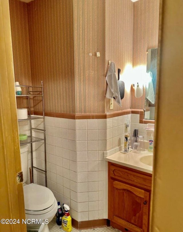 bathroom featuring backsplash, tile walls, toilet, and vanity