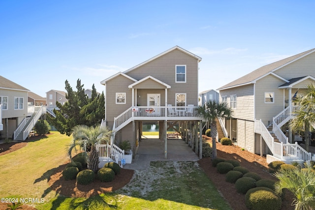 raised beach house with driveway, covered porch, stairway, and a front yard