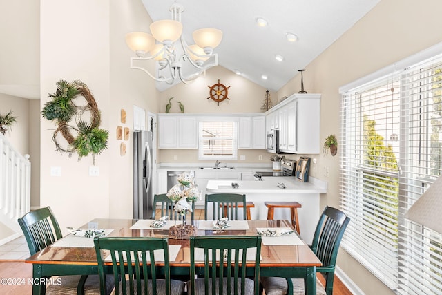 kitchen featuring a peninsula, a sink, white cabinets, light countertops, and appliances with stainless steel finishes