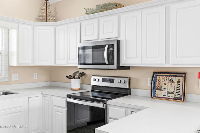 kitchen featuring appliances with stainless steel finishes, light countertops, and white cabinetry