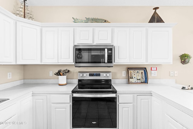 kitchen with appliances with stainless steel finishes, light countertops, and white cabinets