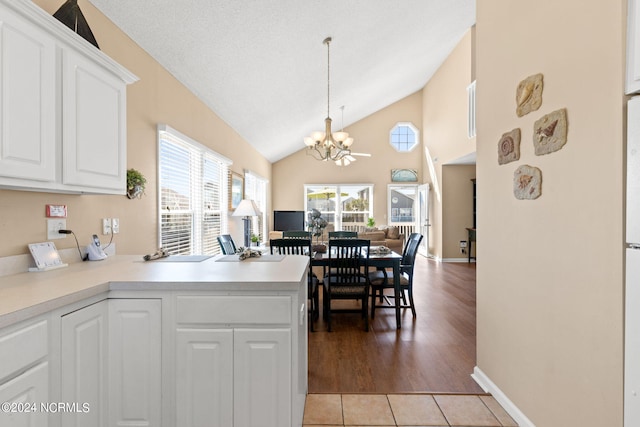 kitchen with open floor plan, plenty of natural light, white cabinetry, and a notable chandelier