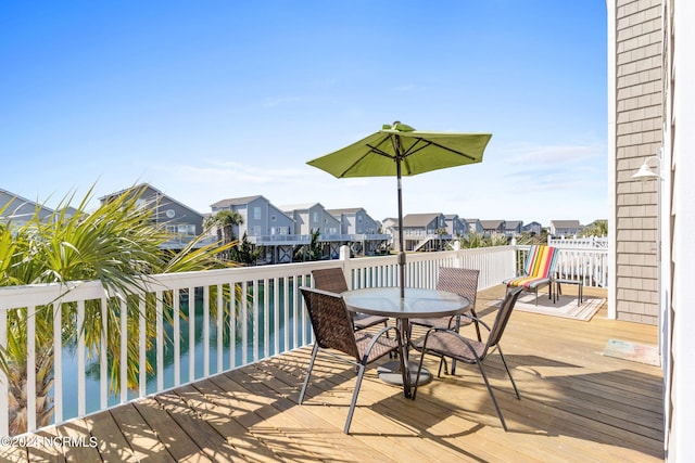 wooden deck with outdoor dining area and a residential view