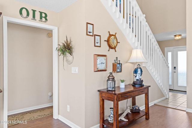 entryway featuring stairway, wood finished floors, and baseboards