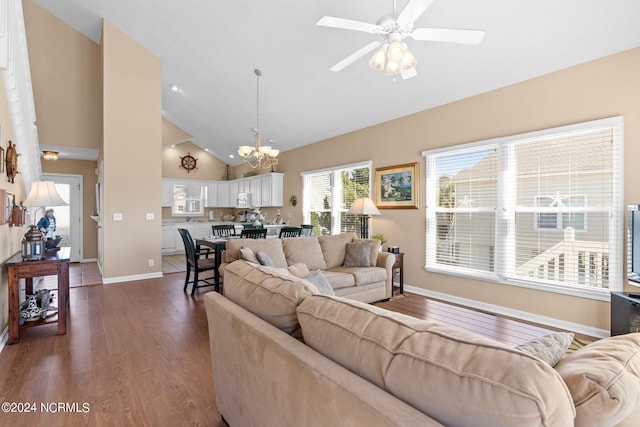 living room with high vaulted ceiling, baseboards, dark wood-type flooring, and ceiling fan with notable chandelier