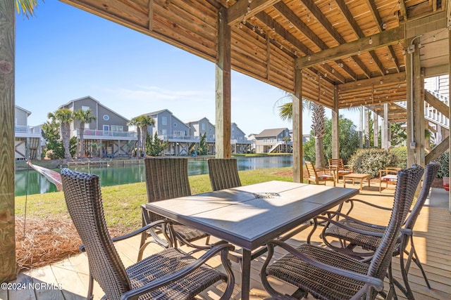 view of patio featuring outdoor dining space, a water view, and a residential view