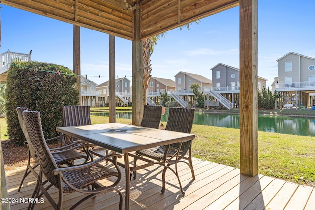 wooden deck with a yard, a water view, and a residential view