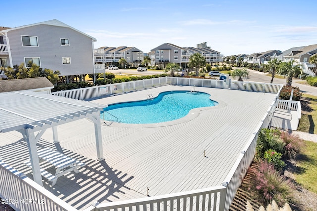 community pool featuring a residential view, fence, and a pergola