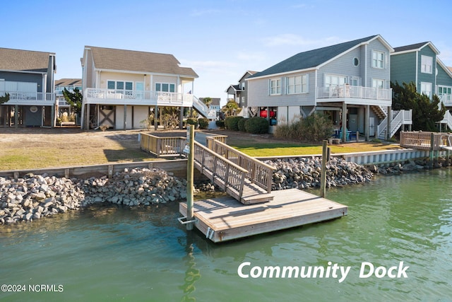 view of dock with a residential view, a deck with water view, and stairway