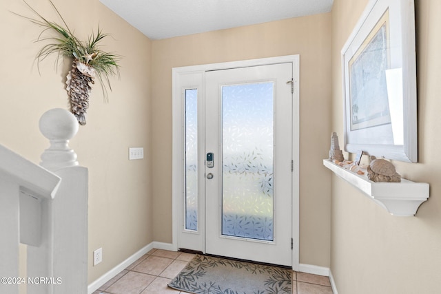 entryway with light tile patterned floors and baseboards