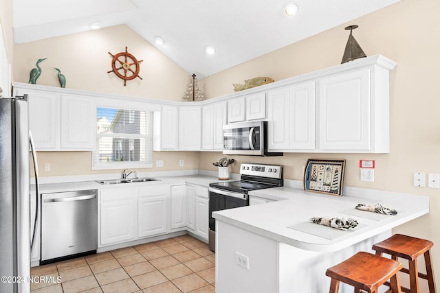 kitchen with light countertops, appliances with stainless steel finishes, white cabinetry, a sink, and a peninsula