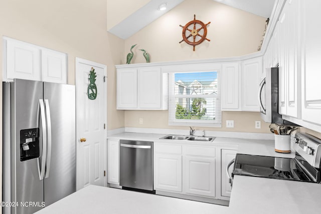 kitchen featuring a sink, white cabinetry, vaulted ceiling, light countertops, and appliances with stainless steel finishes