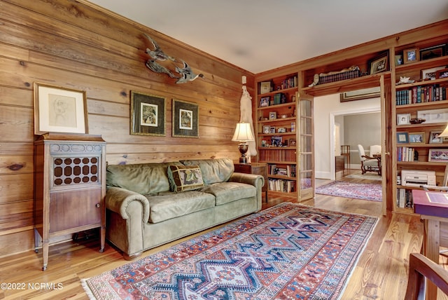 sitting room featuring built in features, wood walls, and light hardwood / wood-style floors