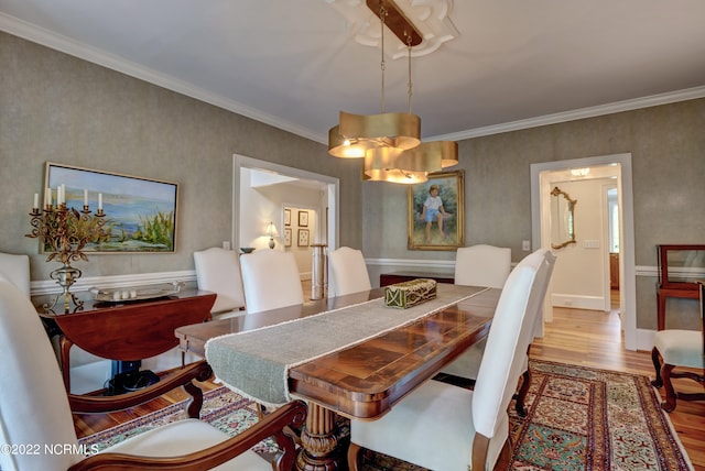 dining space featuring ornamental molding, a notable chandelier, and light hardwood / wood-style flooring