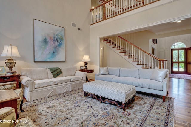 living room featuring hardwood / wood-style floors and a towering ceiling