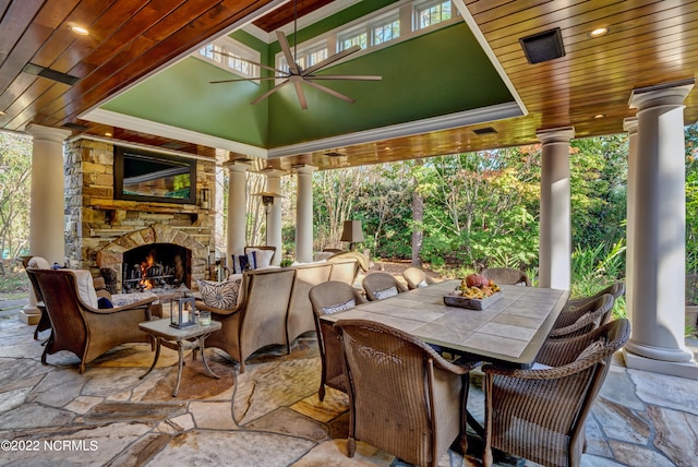 view of terrace featuring an outdoor stone fireplace and ceiling fan