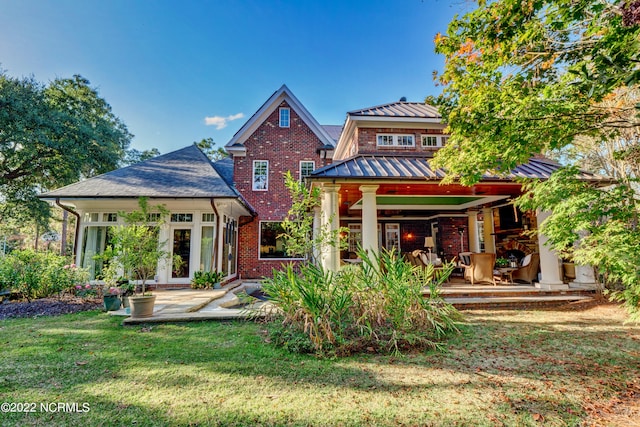 back of house with french doors and a lawn