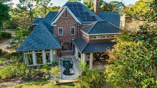 back of property featuring solar panels and a patio