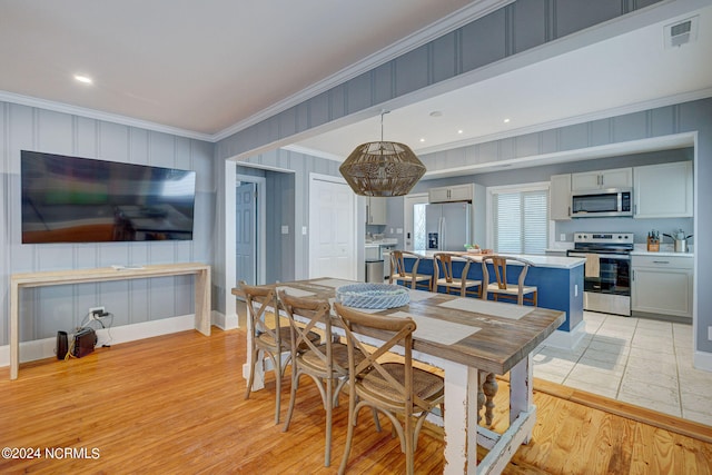 dining space with ceiling fan, light hardwood / wood-style floors, and ornamental molding