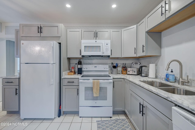 kitchen with gray cabinetry, white appliances, pendant lighting, a chandelier, and tasteful backsplash