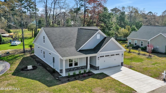 view of front of house featuring a porch, a front yard, and a garage