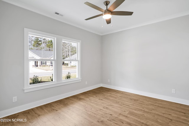 spare room with crown molding, ceiling fan, and light wood-type flooring