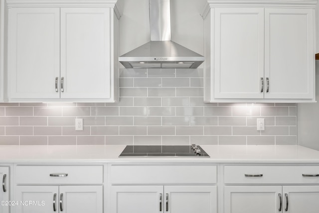 kitchen featuring white cabinetry, wall chimney range hood, tasteful backsplash, and black electric cooktop