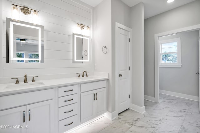 bathroom featuring vanity, wood walls, and a wealth of natural light