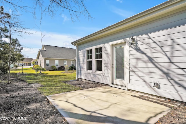 property entrance with a yard and a patio