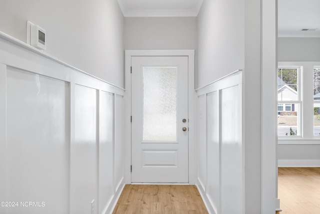 doorway to outside with light hardwood / wood-style flooring and ornamental molding