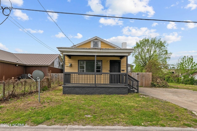 bungalow-style home with a front lawn and covered porch