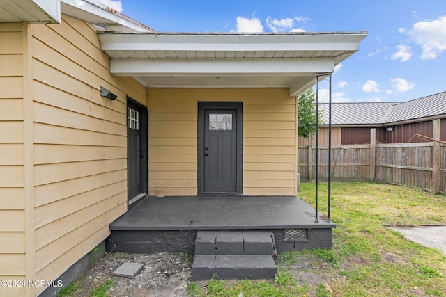 view of exterior entry featuring a yard