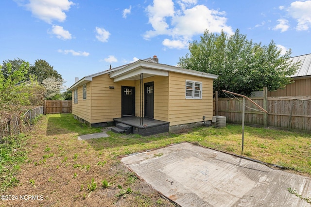 back of property featuring central air condition unit, a lawn, and a patio