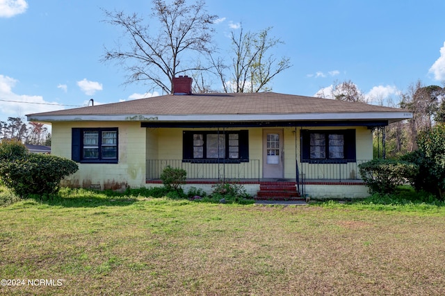 view of front of house with a front yard and covered porch