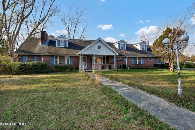 cape cod home with a front yard and covered porch